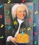 JS Bach holding a birthday cake with 1 lit candle